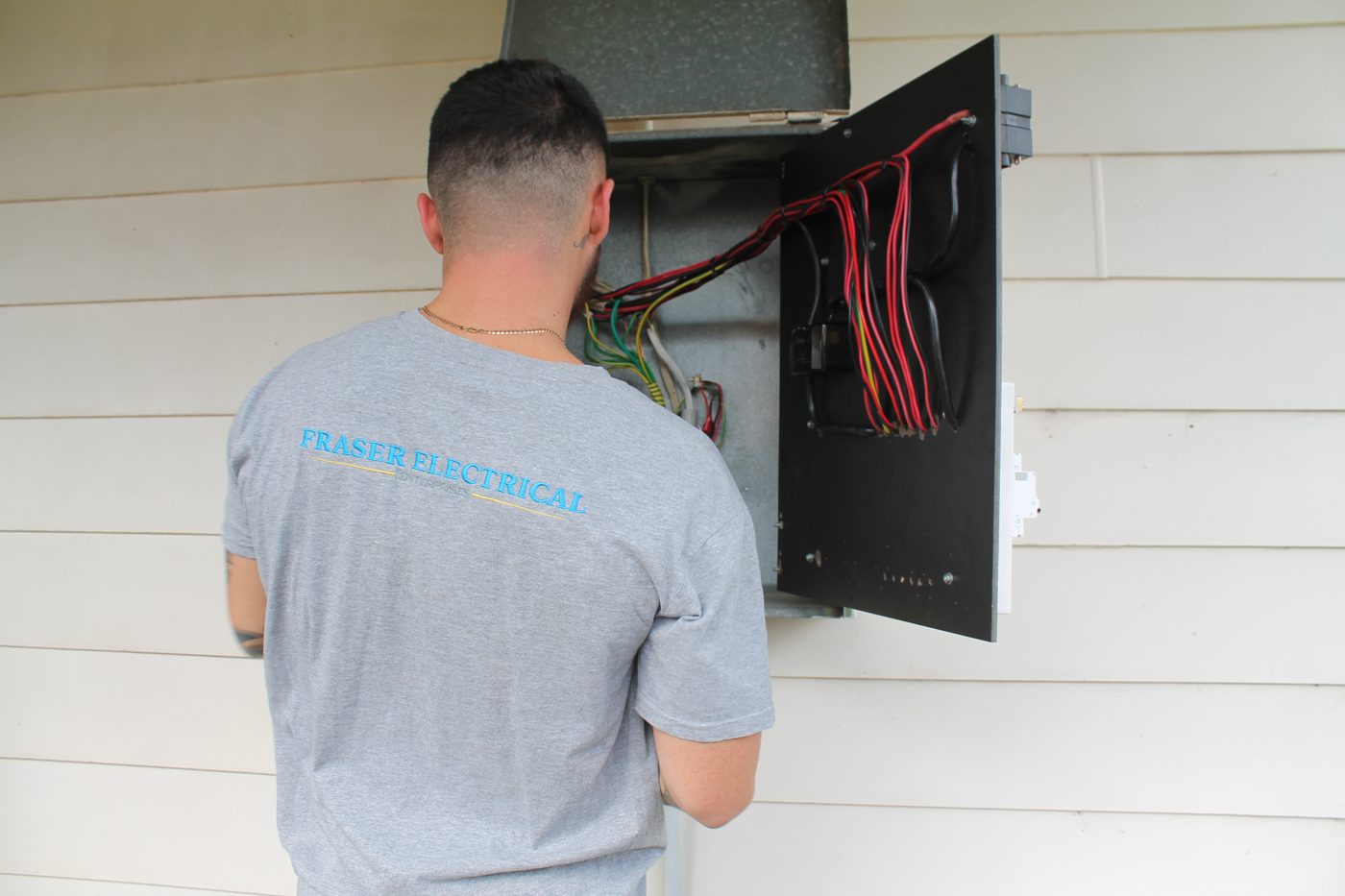 Fraser Electrical technician testing a switchboard