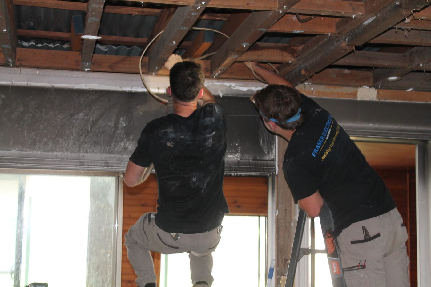 Two Fraser Electrical technicians working overhead